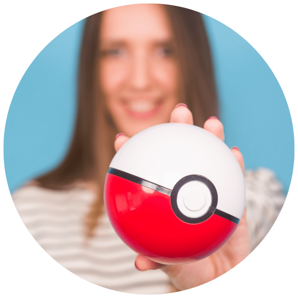 A woman holds out a Pokéball in front of her.