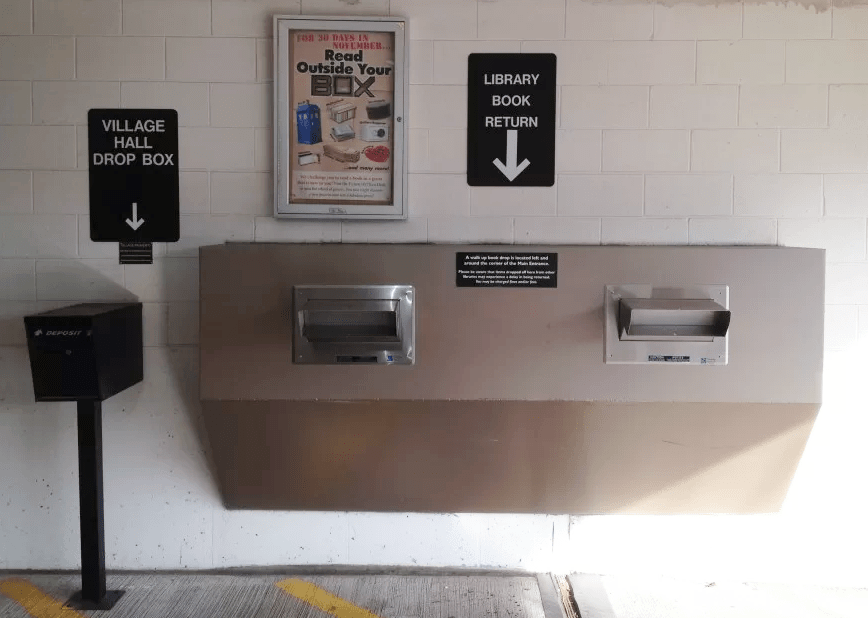 Drive-through book drop in the parking garage exit. Sign reads "Library book return."