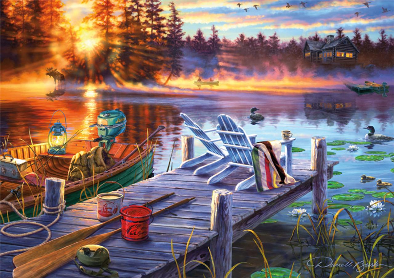 Darrell Bush captures an picturesque morning with Morning Magic, a 300-large piece puzzle, by Buffalo Games. Two Adirondack chairs sit on the edge of a dock overlooking the lake. The sun rises from behind the tree line reflecting on the water as several ducks swim by. A boat is packed with supplies ready for an early morning fishing trip. A bonus puzzle poster is also included so that you have a handy reference of what the completed puzzle should look like while you put yours together.