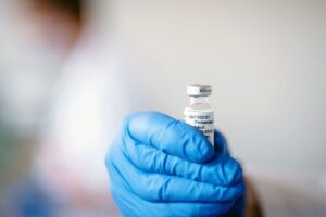doctor holding vaccine vial