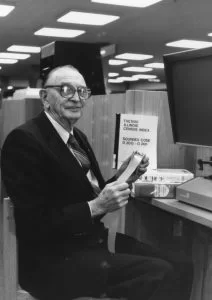 Harold Weary in the genealogy room, sitting at microfilm machine, circa 1980. Black and white.