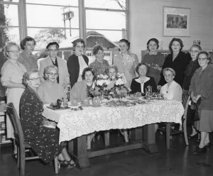 Ladies around a table for library
anniversary party, 1955. Black and white.