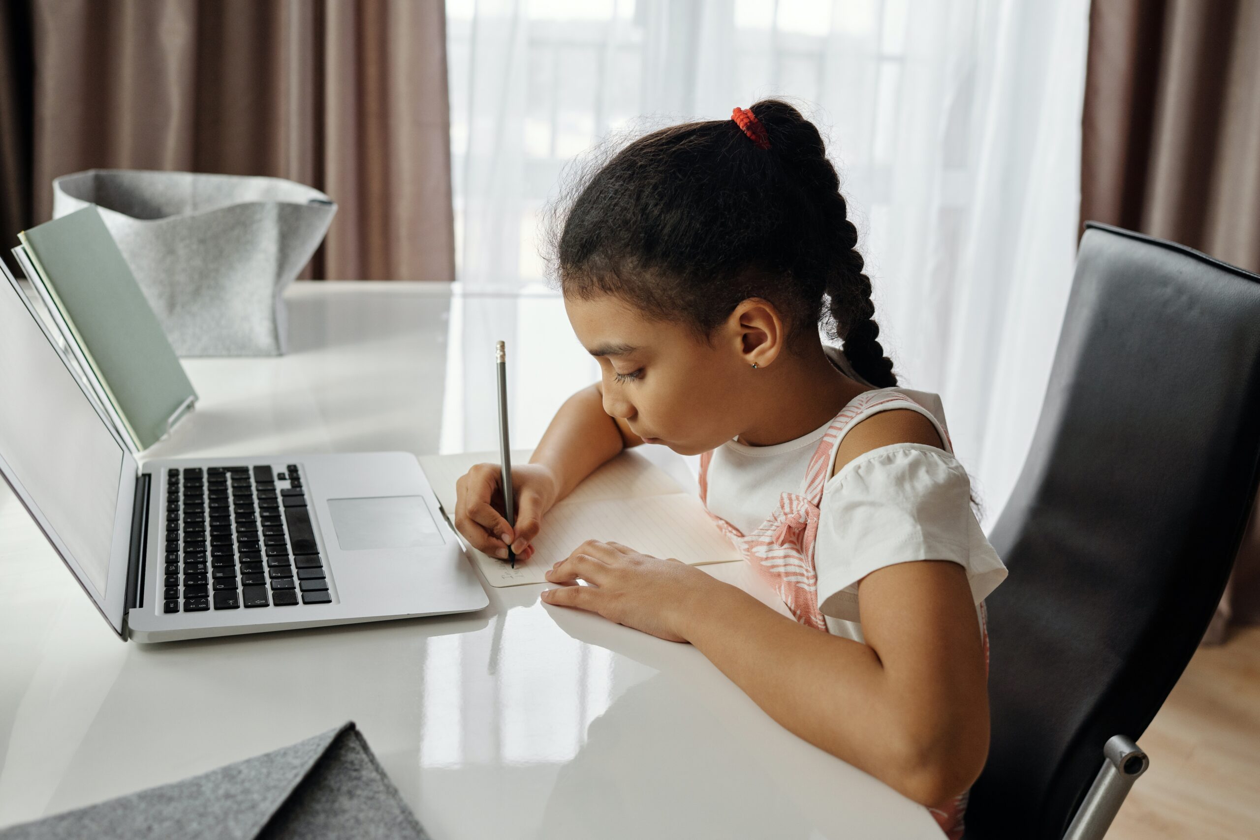 little-girl-doing-her-homework at a laptop