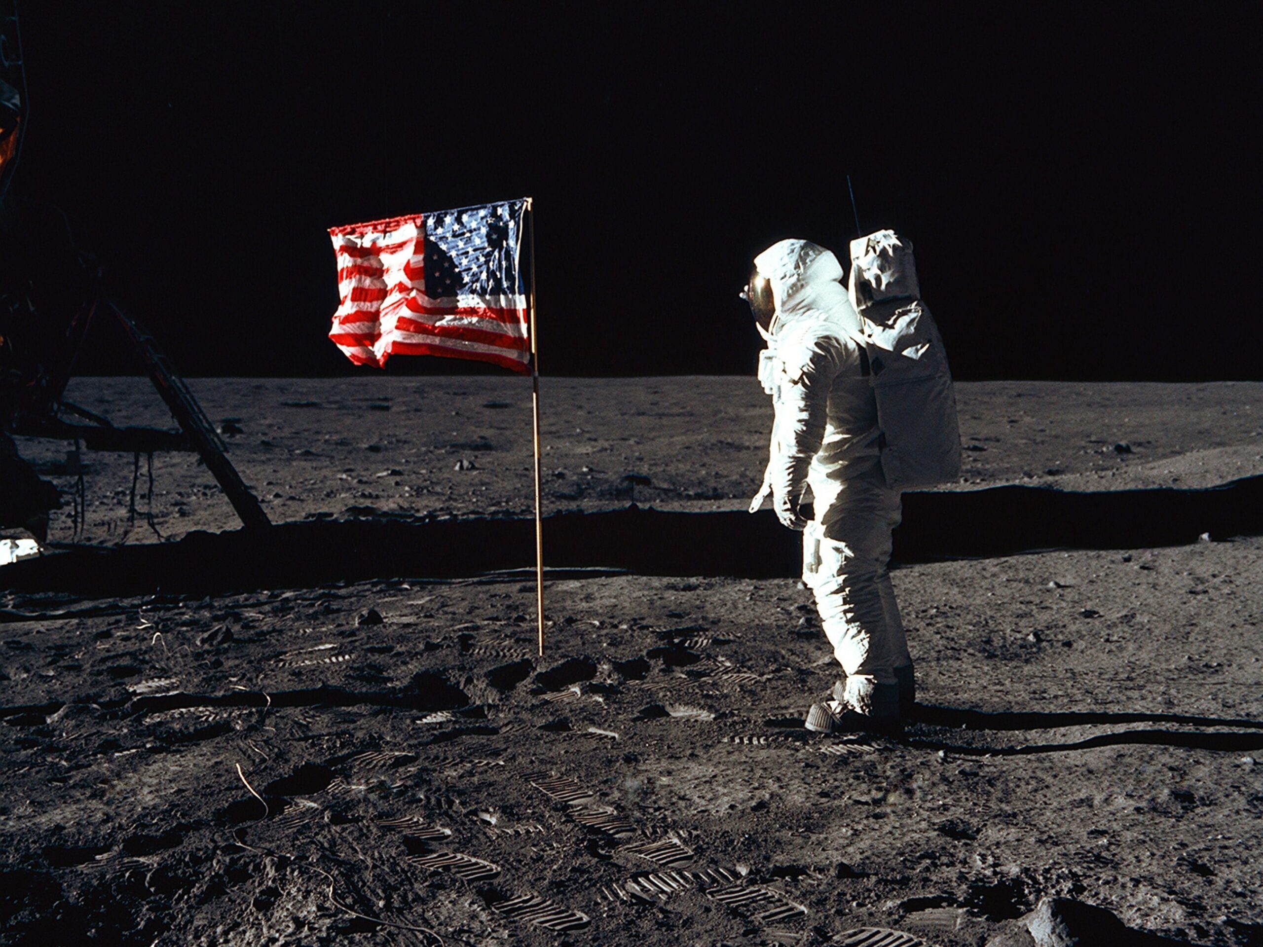 astronaut on the moon with U.S. flag