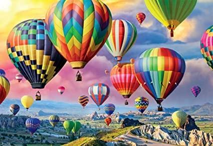 2000 piece jigsaw puzzle when completed depicts collection of beautiful balloons floating above a vista. Poster of completed image included in container.