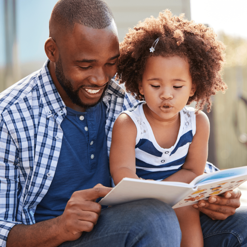 A father reads a children's book with his daughter.