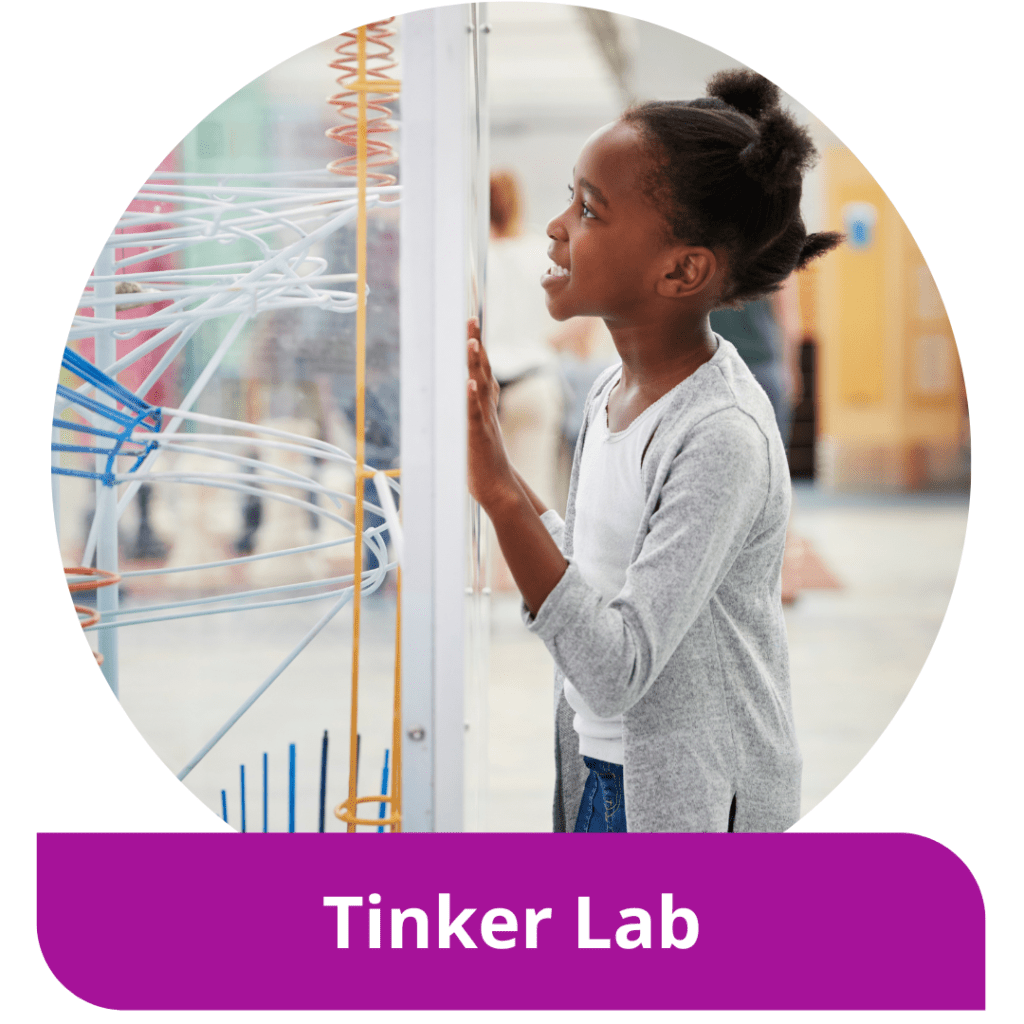 A girl gazes excitedly at a tinker experiment. Text reads: Tinker Lab
