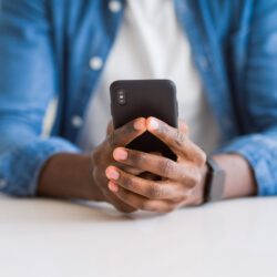 Close up of a pair of hands holding a cell phone.