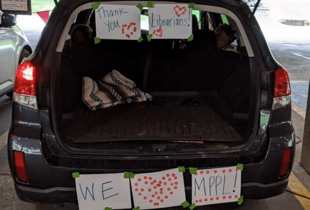 An open trunk awaiting materials has handmade paper signs taped to the bumper that read: "Thank you librarians! We heart MPPL!"